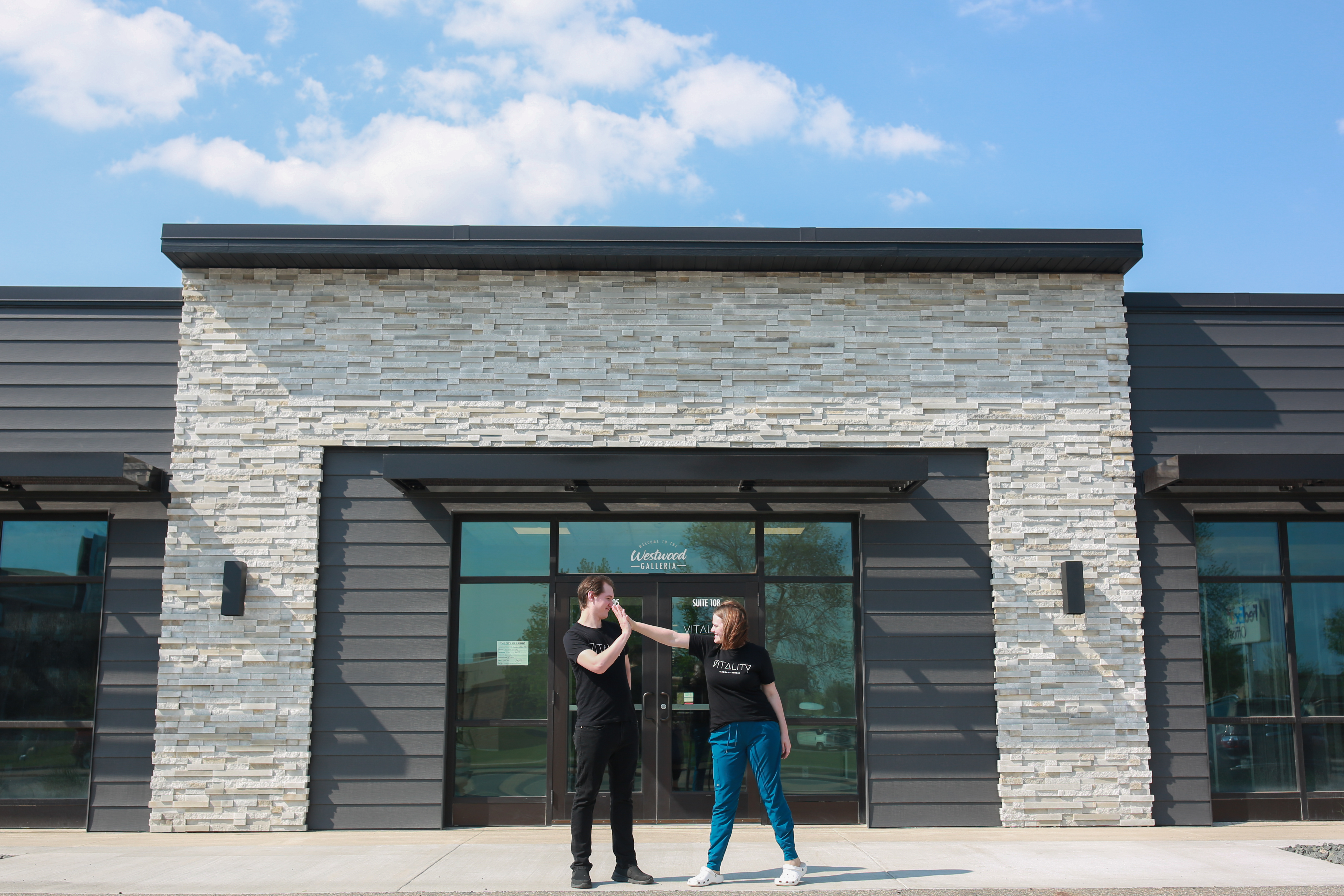 photo of the entrance to vitality massage studio on opening day, with a floral arrangement and balloons
